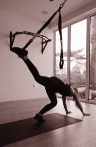 see how the TRX is around her ankle in this photo? The next move is to kick the other foot up to "meet it."